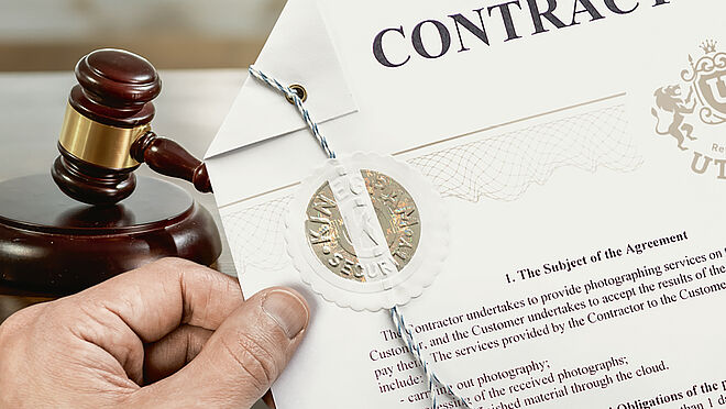 Image of hand holding a notary certificate stamped with a gold color secure KINEGRAM Notary Seal