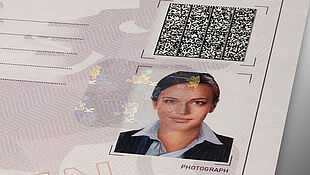 Secure codes and labels with KINEGRAM Close-up of a paper certificate that is protected by a KINEGRAM patch and a secure Visible Digital Seal barcode